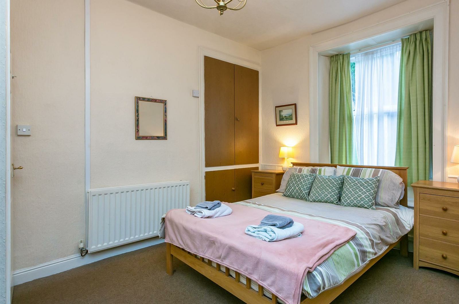 Example guest room with pink bedding and green curtains